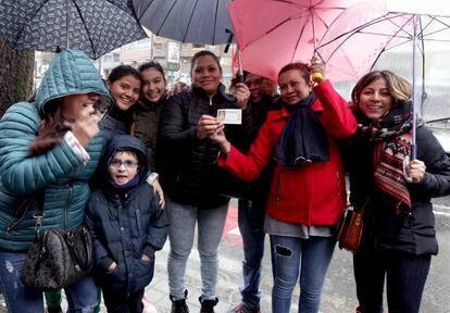 Beti muestra un décimo premiado con el primer número junto a su familia frente a la administración de Deusto número 19, en Bilbao.