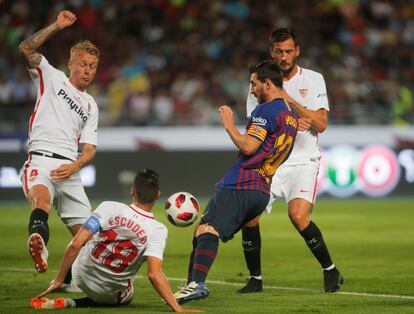 Messi de Barcelona en una jugada con Sergio Escudero y Simon Kjaer.