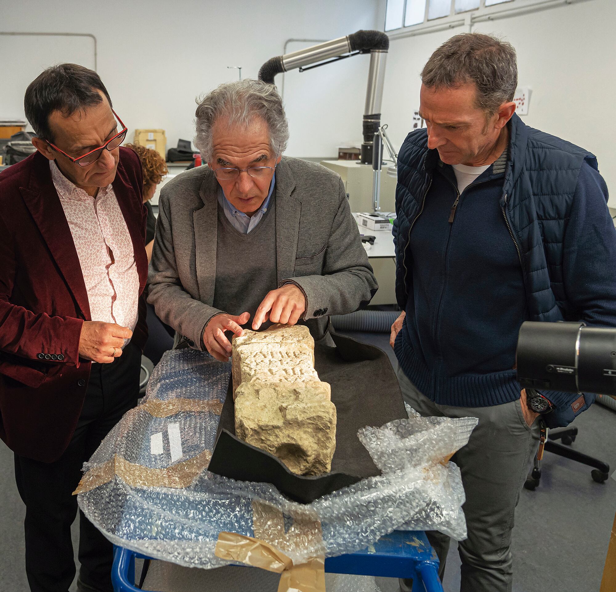 Los investigadores Javier Velaza, Juantxo Agirre y Joaquin Gorrotxategi estudiando la epigrafia del ara de Larunbe.