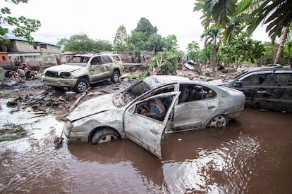 A man checks a vehicle damaged by flooding after Hurricane Beryl hit the Venezuelan coast.