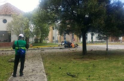 Fotografía facilitada por personal de la escuela en la que se aprecian los restos, todavía en llamas, del coche bomba usado en el atentado terrorista de Bogotá.