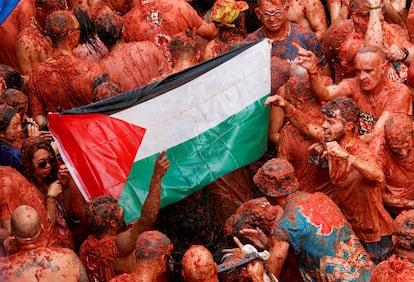 Varios participantes extienden una bandera de Palestina durante la celebración.