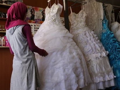 Una joven siria de 14 a&ntilde;os elige su vestido de boda en el campo de refugiados de Za&#039;atari, en Jordania. 