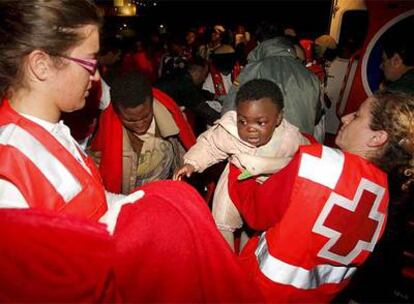 Miembros de la Cruz Roja atienden los bebés llegados en patera al puerto de Almería.