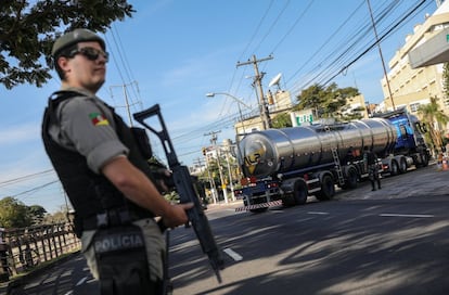 Con menos bloqueos y una mayor salida de gasolina desde las refinerías, los autobuses y transportes de mercancías empezaron a retomar su actividad. En la imagen, un policía vigila la entrada a una estación de servicio en Porto Alegre (Brasil), el 29 de mayo de 2018.