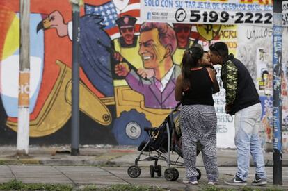 Una familia en Buenos Aires ante un mural de Macri.