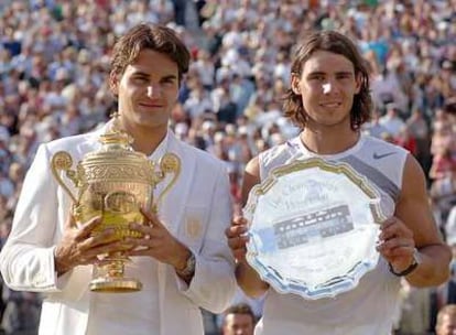 Roger Federer y Rafael Nadal muestran los trofeos, la copa y la bandeja, que les reconocen como campeón y finalista de Wimbledon.