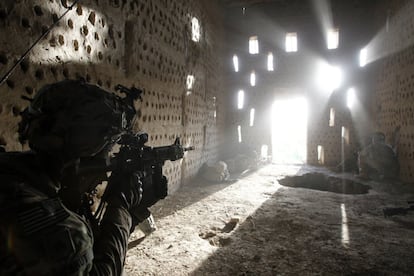 Un marine apunta con su rifle la puerta de una vivienda, después de ser atacados por un grupo de talibanes durante una patrulla en el distrito Zharay en la provincia de Kandahar, en el sur afgano.