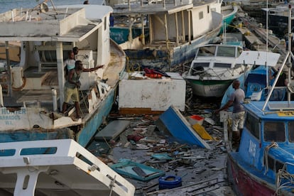 Pescadoras junto a los barcos dañados tras el paso del huracán 'Beryl' en el puerto de Bridgetown (Barbados), el 2 de julio. 
