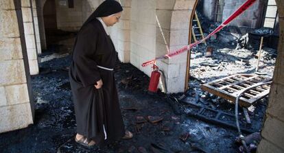 Una monja inspecciona los daños en la iglesia del milagro de los panes y los peces.