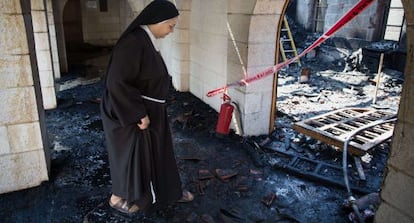 Una monja inspecciona los daños en la iglesia del milagro de los panes y los peces.