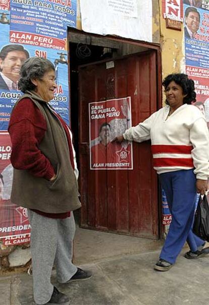 Dos peruanas, ante una casa con propaganda del candidato Alan García.