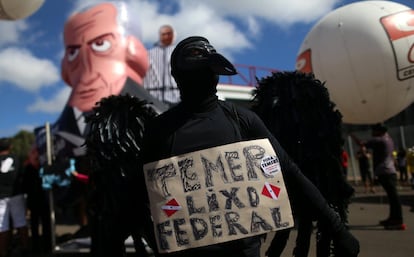 O presidente enfrenta novos protestos por conta das delações de diretores do grupo JBS que lhe implicam diretamente em fatos de corrupção que estão sendo investigados. Na imagem, um manifestante segura um cartaz que diz: 'Temer, lixo federal' durante o protesto.