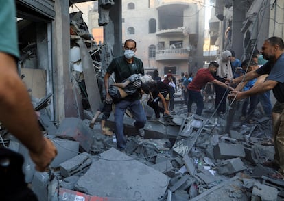 Un hombre traslada a un niño herido tras un bombardeo del ejército de Israel en Jan Yunis. 