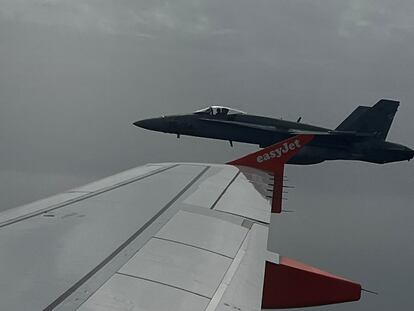 Spanish F-18 jet fighter, seen through plane window, escorts an Easyjet flight heading from London to the Spanish holiday island of Menorca, after a hoax bomb threat by an 18-year-old British passenger, July 3, 2022. Marcus Torr/via REUTERS  ATTENTION EDITORS - THIS IMAGE HAS BEEN SUPPLIED BY A THIRD PARTY. MANDATORY CREDIT. NO RESALES. NO ARCHIVES.