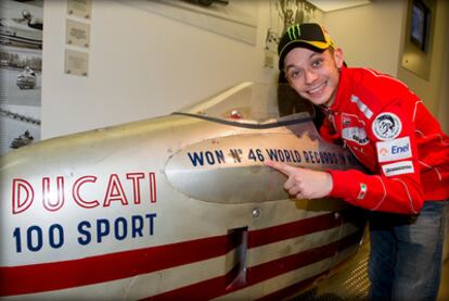 El piloto italiano Valentino Rossi posa junto a un modelo antiguo de Ducati durante su visita al museo de la marca en Bolonia.