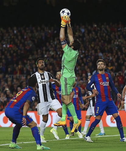 El guardameta de la Juventus, Gianluigi Buffon (c), captura el balón ante los jugadores del Barcelona, el uruguayo Luis Suárez (i) y Gerard Piqué.