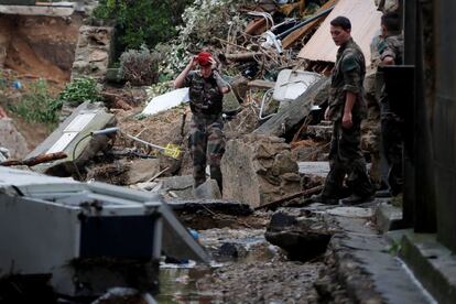 Soldados caminan entre los escombros de los daños provocados por las inundaciones en Villegailhenc (Francia).