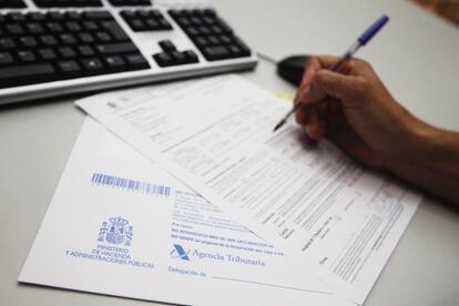 Una persona rellena a mano una declaración.