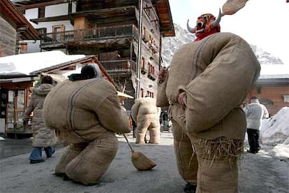 Los <i>hombres de paja</I> salen a la calle en la ciudad suiza de Evolene, persiguiendo a escobazos a los espectadores de esta fiesta carnavalesca.