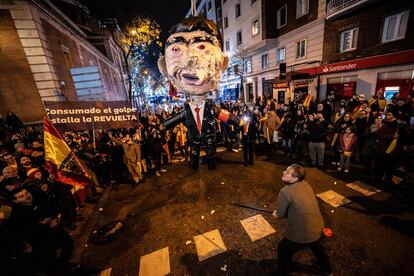 Un hombre se prepara para golpear un muñeco de Pedro Sánchez, la pasada Nochevieja cerca de la sede del PSOE en Madrid.