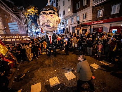 Un hombre se dispone a apalear un muñeco con la figura de Pedro Sánchez en una manifestación en las cercanías de la calle de Ferraz en Madrid, en Nochevieja.