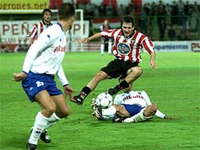 Un jugador del Logroñés intenta evitar la entrada de Aguado, del Zaragoza.