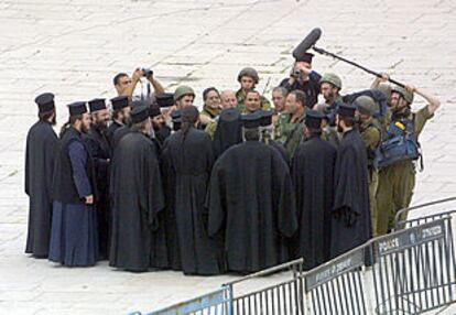 Soldados israelíes conversaban ayer con frailes greco-ortodoxos en la plaza de la Basílica de la Natividad en Belén.