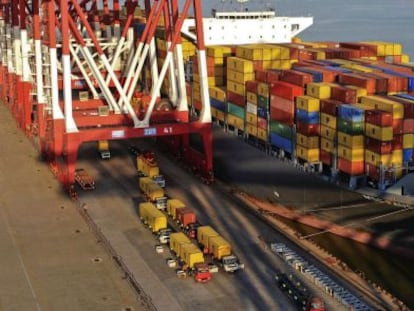 Camiones trasladan contenedores de un barco en el puerto de Qingdao (China)