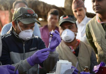 Los veterinarios preparan un dardo tranquilizante para el rinoceronte.