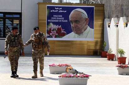 Una pareja de militares pasea delante de la catedral caldea de San José en Bagdad, este lunes.