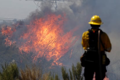 Bombeiro monitora o avanço do fogo em Santa Clarita, Califórnia.