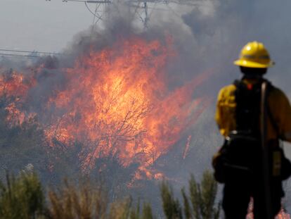 Un bombero monitorea las llamas en Santa Clarita, California, este lunes.