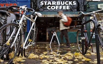 Un hombre pasa por delante de una cafeter&iacute;a de la cadena Starbucks en Londres, Reino Unido.