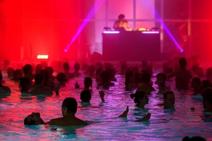 La gente asiste a una sesión del DJ británico Luke Abbott (C) en una piscina gigante durante el Antigel Festival ('festival anticongelante'), en Confignon, cerca de Ginebra (Suiza).