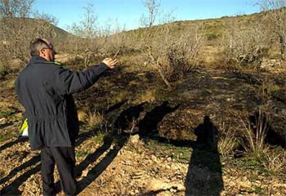 Un policía local de Cabanes (Castellón) muestra los restos del incendio atribuido a la caída del meteorito.