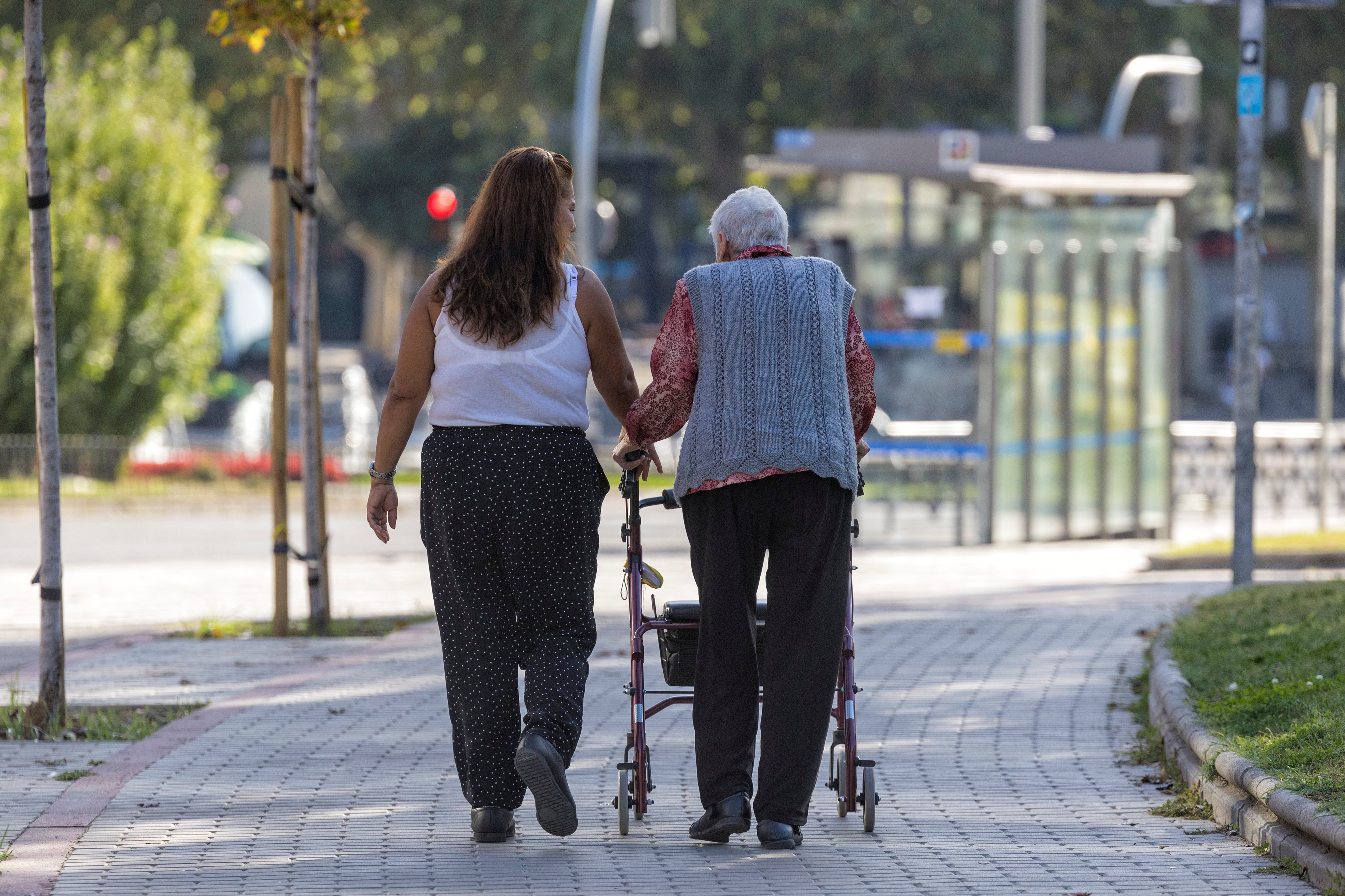 Una mujer acompaña a una mujer mayor, en octubre de 2023. 