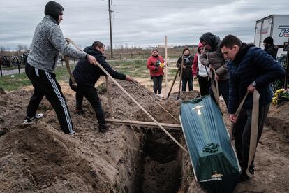 El joven Oleksandr Smagliuk, a la izquierda de la imagen, de 21 años, ayuda a enterrar el ataúd de su pariente Mykhailo Romaniuk en un cementerio de Bucha. Iban juntos en bicicleta cuando Romaniuk fue asesinado a tiros en la calle Yablonska. Ocurrió el pasado 6 de marzo, durante la ocupación rusa de esta ciudad dormitorio próxima a Kiev. 