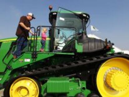 Un agricultor y un niño en un tractor John Deere 956