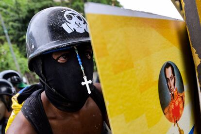 Un opositor venezolano tras un escudo decorado con un retrato de Simón Bolívar durante los enfrentamientos contra la policía en Caracas, el 7 de junio de 2017.