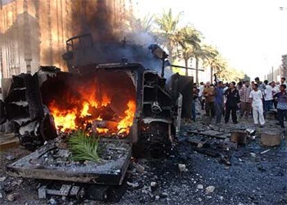 Iraquíes junto a un blindado Bradley, incendiado durante los combates en la céntrica calle Haifa de Bagdad.