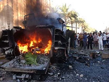 Iraquíes junto a un blindado Bradley, incendiado durante los combates en la céntrica calle Haifa de Bagdad.