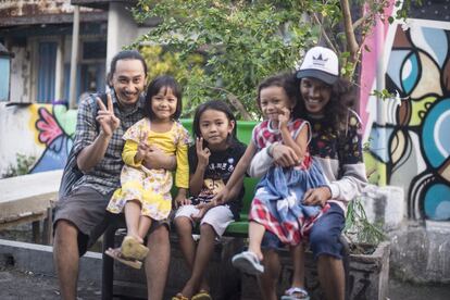 El artista urbano de Indonesia X-Go (izquierda), junto a su compañero Brian 'Vark' (derecha) y un grupo de niños de Kedondong, Surabaya, durante la visita al kampung de esta periodista.