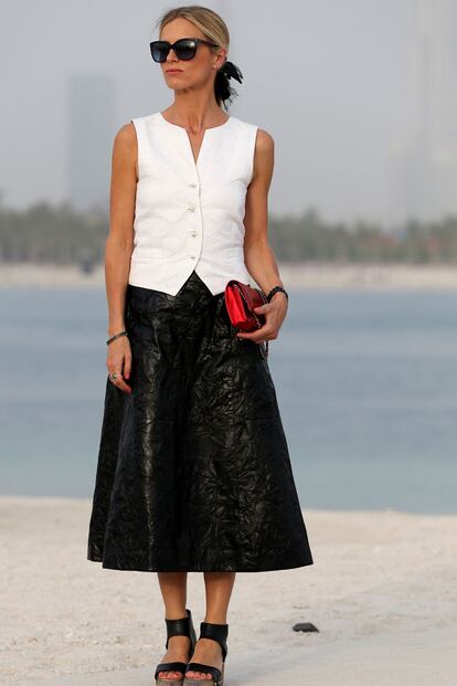 Laura Bailey eligió chaleco blanco y falda midi negra para asistir al último desfile de Karl Lagerfeld. Todo un acierto el punto de color gracias al bolso rojo.