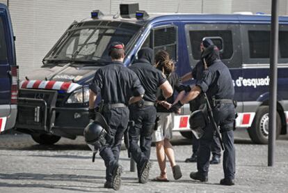 Cuatro <i>mossos</i> conducen detenido a un miembro del 15-M.