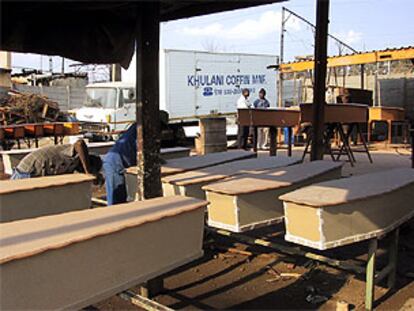 Trabajadores lijan ataúdes en la fábrica de la empresa Khulani, en Soweto.