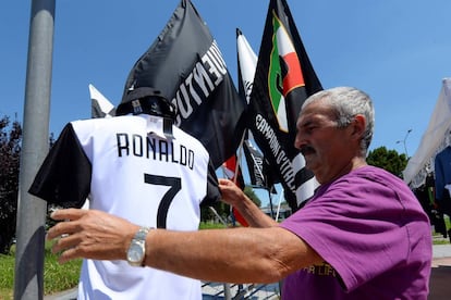 Un vendedor acomoda la camiseta del nuevo fichaje de la Juventus, Cristiano Ronaldo.