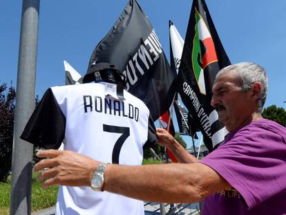 Un vendedor acomoda la camiseta del nuevo fichaje de la Juventus, Cristiano Ronaldo.