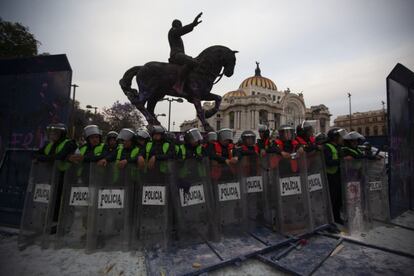 grupos de policías protegen las estatuas que rodean el Palacio de Bellas Artes.