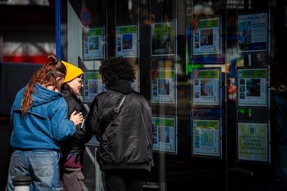 Jóvenes observando el mostrador de una inmobiliaria en Madrid en mayo.